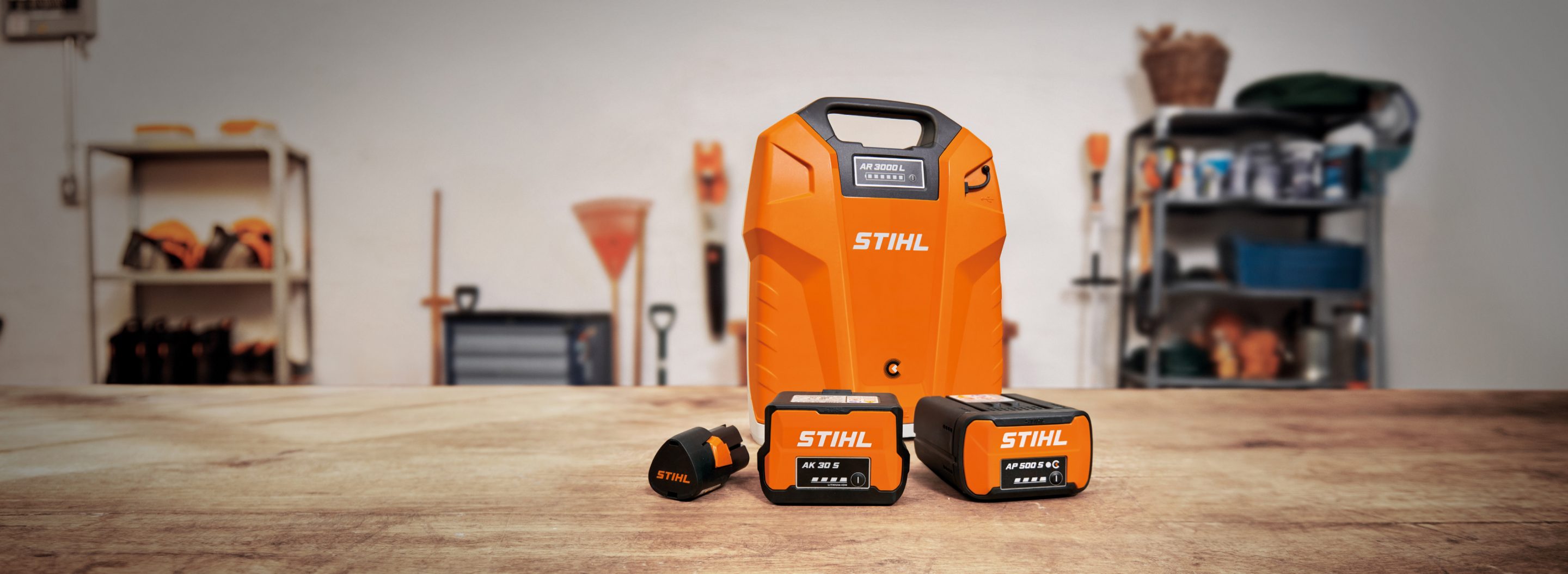Four batteries with STIHL battery technology on a shelf in a workshop