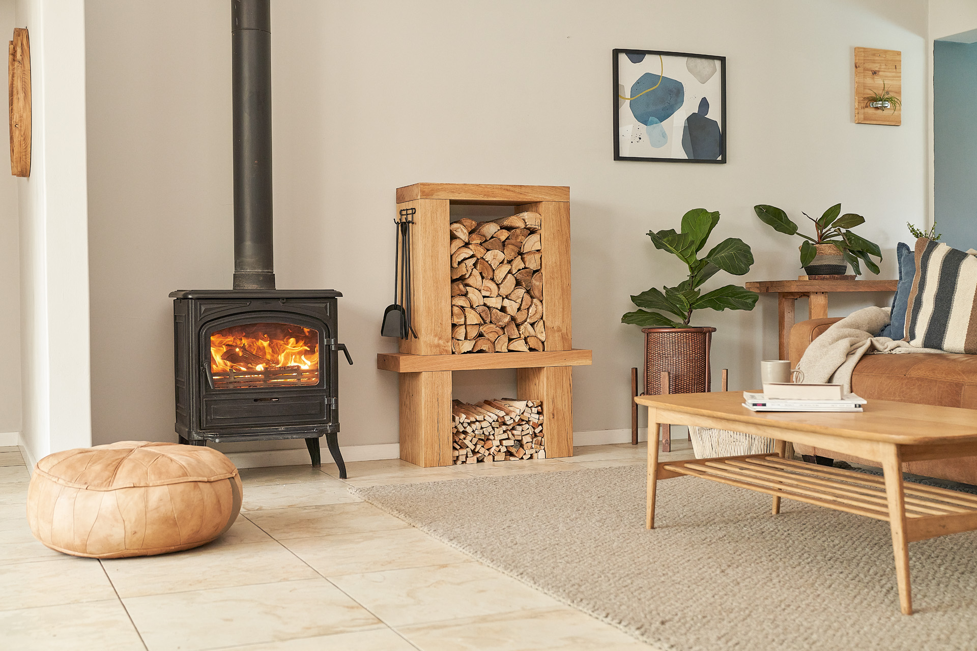 A furnished room with fireplace and indoor firewood rack