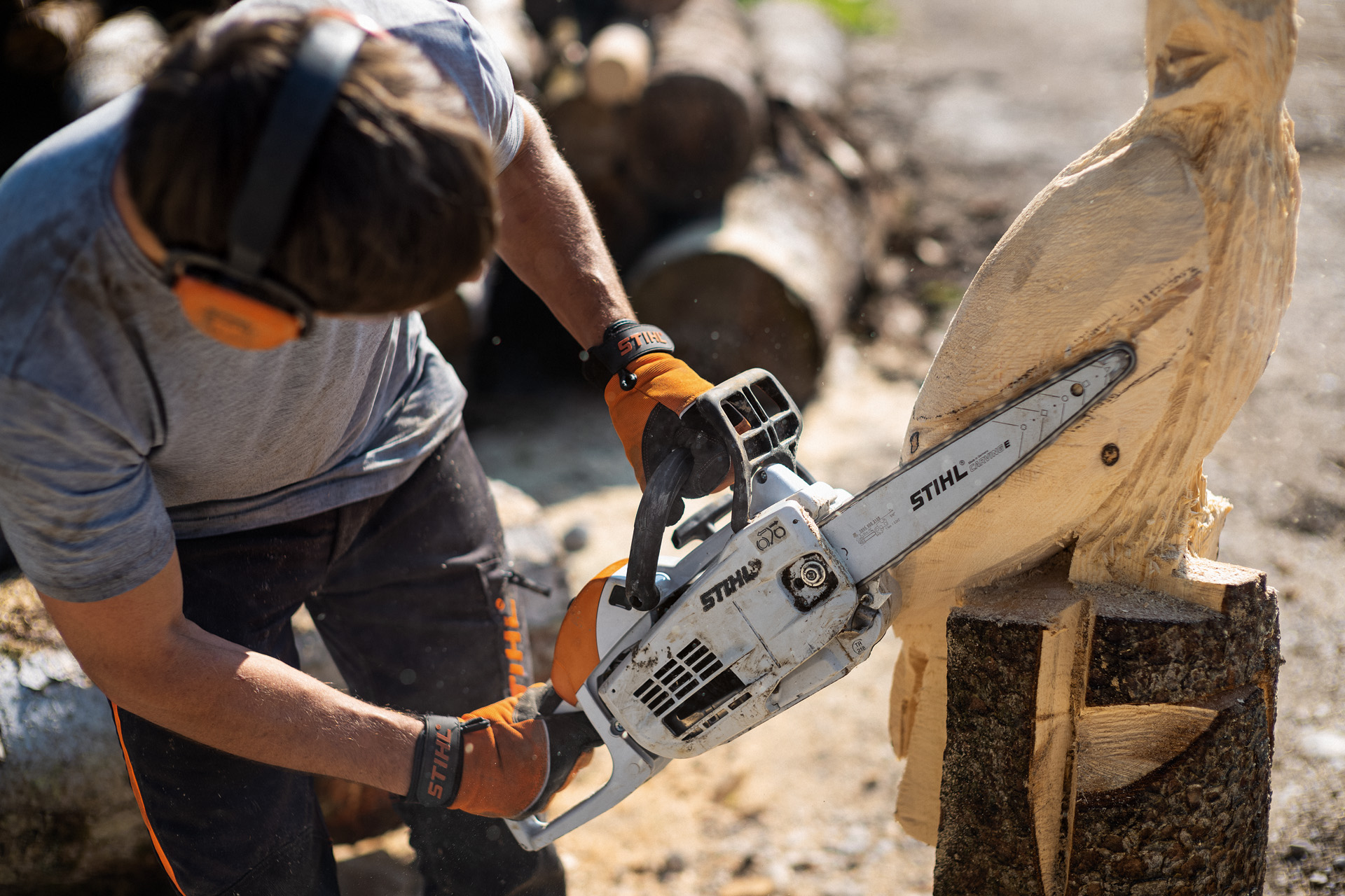 A man carving an owl with a STIHL chainsaw